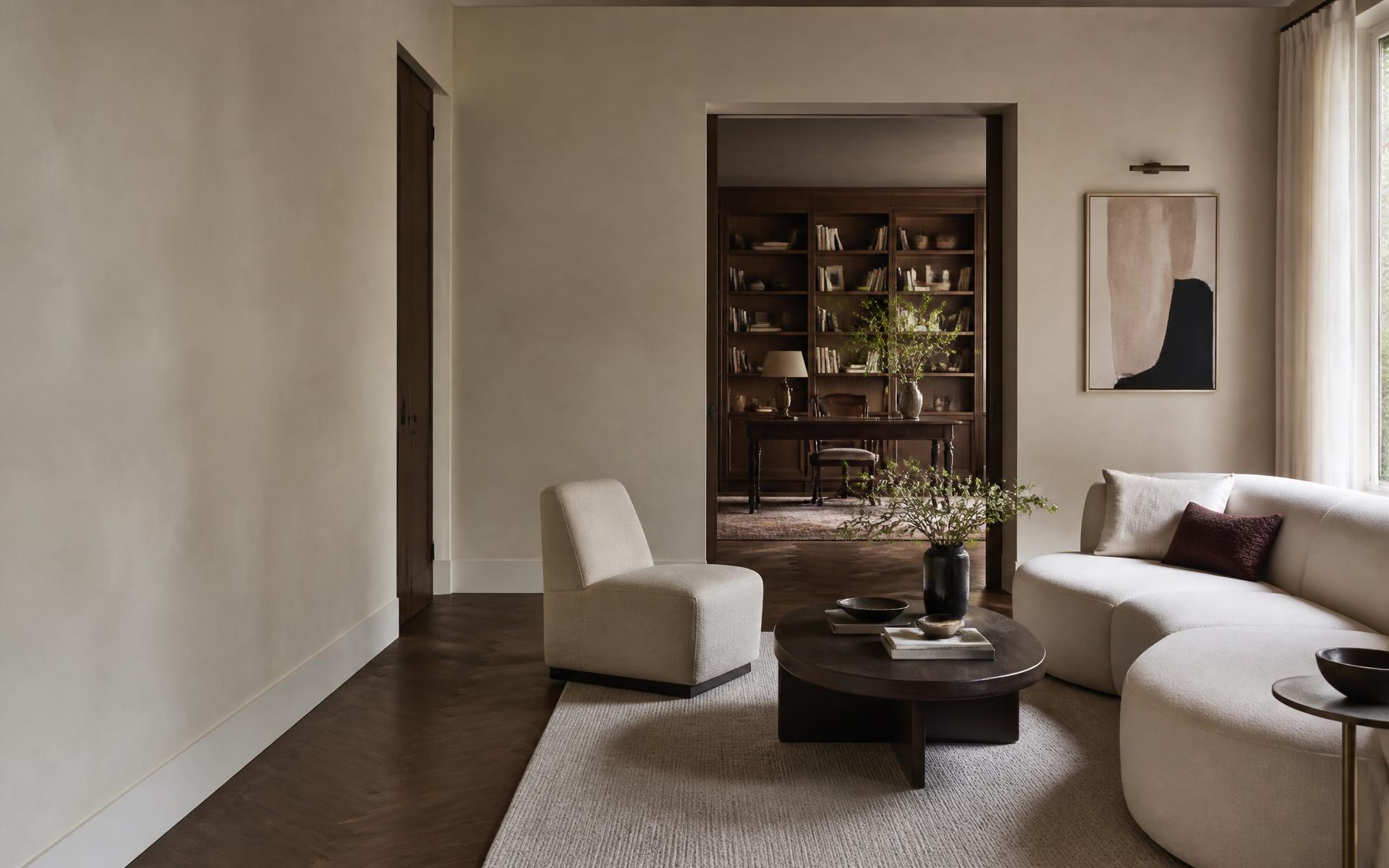 Considered living room with warm plaster, dark timber and ivory upholstery